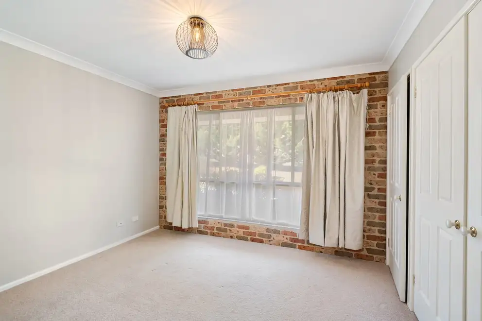 An empty carpeted room with the curtains drawn back