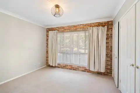 An empty carpeted room with the curtains drawn back