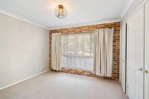 An empty carpeted room with the curtains drawn back