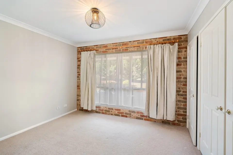 An empty carpeted room with the curtains drawn back